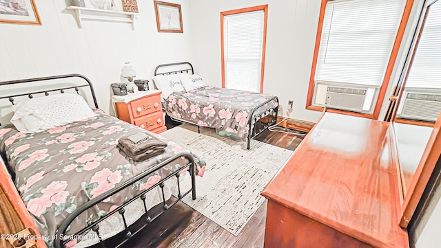 bedroom with hardwood / wood-style floors, cooling unit, and a baseboard heating unit