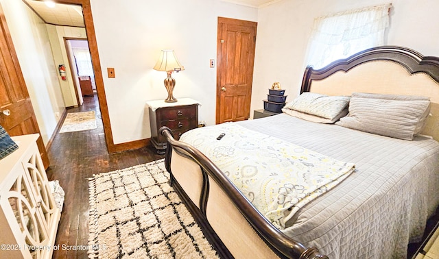 bedroom with dark hardwood / wood-style floors and ornamental molding