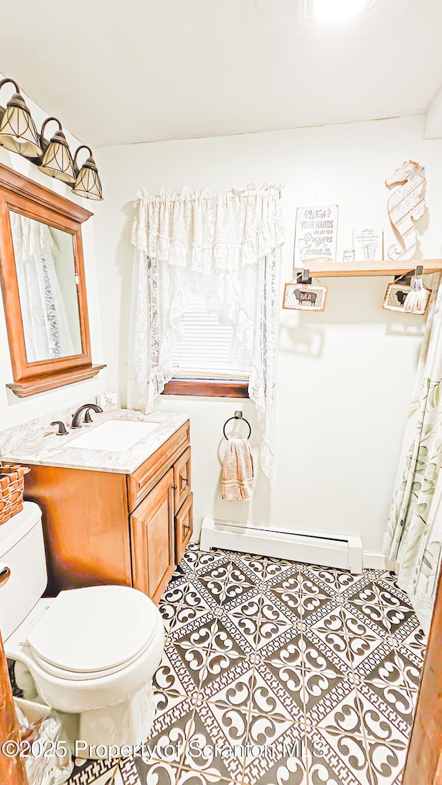 bathroom featuring tile patterned floors, vanity, toilet, and baseboard heating