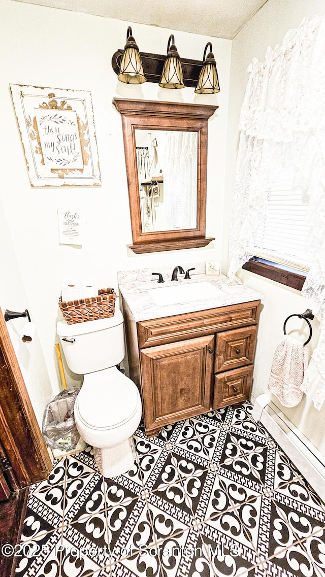 bathroom with tile patterned floors, vanity, a textured ceiling, and toilet