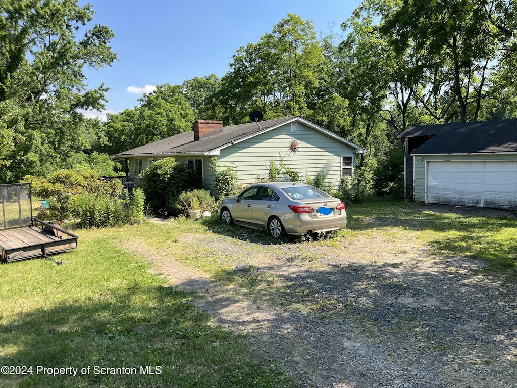 exterior space with a yard, a garage, and an outdoor structure