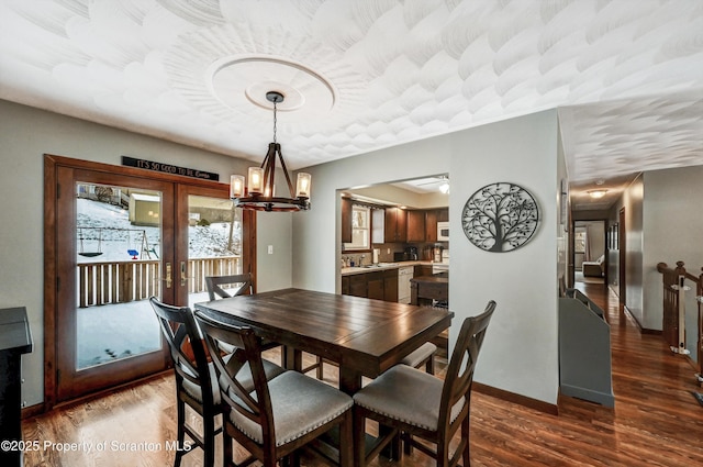 dining space featuring sink, dark hardwood / wood-style flooring, and french doors