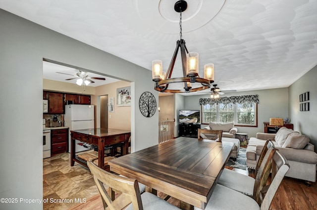 dining area with ceiling fan with notable chandelier