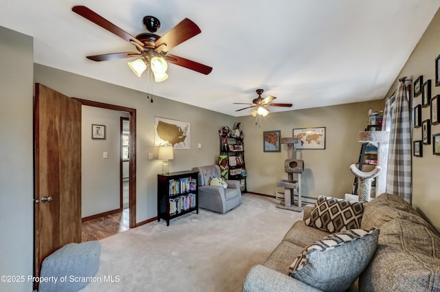 carpeted living room with ceiling fan, a fireplace, and a baseboard heating unit