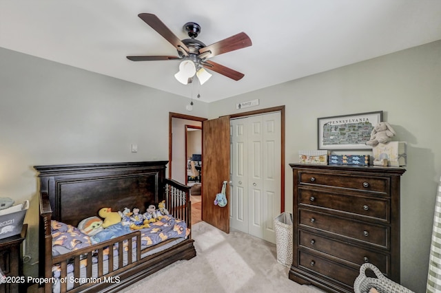 carpeted bedroom with ceiling fan and a closet