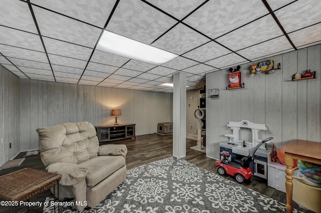 living area featuring a paneled ceiling and dark hardwood / wood-style floors