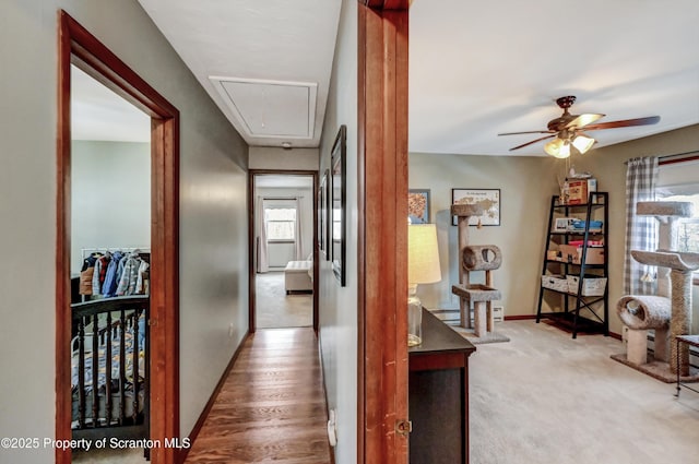 hall with a baseboard heating unit and carpet