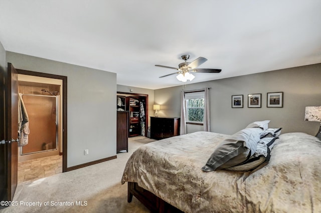 carpeted bedroom featuring a spacious closet, a closet, ceiling fan, and ensuite bathroom