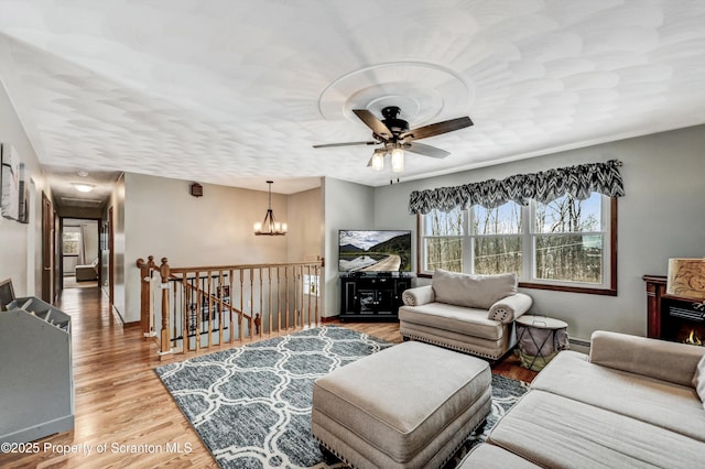 living room featuring hardwood / wood-style flooring and ceiling fan with notable chandelier