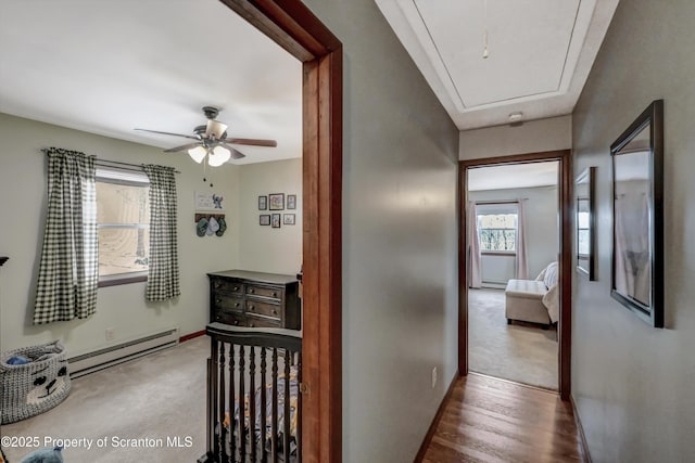 hallway featuring a baseboard radiator and carpet