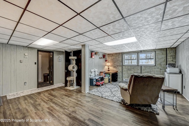 unfurnished living room with wood-type flooring and a drop ceiling