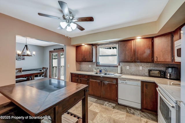 kitchen with french doors, sink, tasteful backsplash, hanging light fixtures, and white appliances