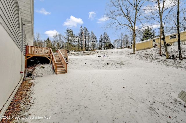 snowy yard featuring a wooden deck