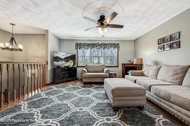 living room featuring ceiling fan with notable chandelier and dark hardwood / wood-style flooring