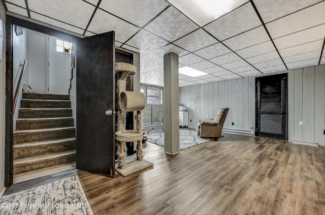 basement featuring hardwood / wood-style flooring and a paneled ceiling