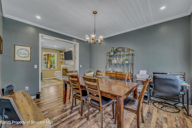 1612 Whitetail Run, Moscow, PA 18444 - dining area with wood finished floors, a chandelier, crown molding, a fireplace, and recessed lighting