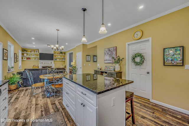 1612 Whitetail Run, Moscow, PA 18444 - kitchen with crown molding, a chandelier, white cabinets, a center island, and dark wood-type flooring
