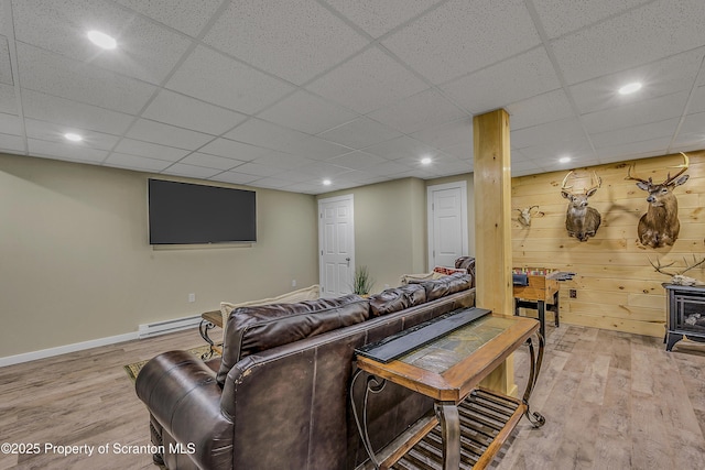 1612 Whitetail Run, Moscow, PA 18444 - living room featuring wood finished floors, a baseboard heating unit, recessed lighting, a paneled ceiling, and a wood stove
