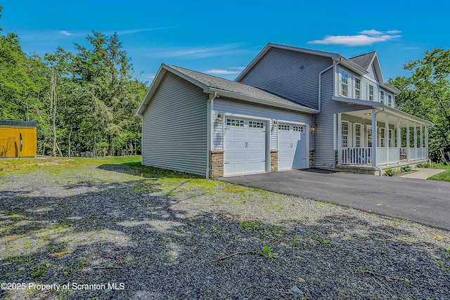 1612 Whitetail Run, Moscow, PA 18444 - view of side of home with a porch, a garage, driveway, and stone siding