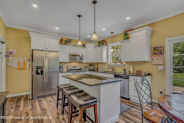 1612 Whitetail Run, Moscow, PA 18444 - kitchen featuring stainless steel appliances, white cabinetry, ornamental molding, hardwood / wood-style flooring, and decorative light fixtures