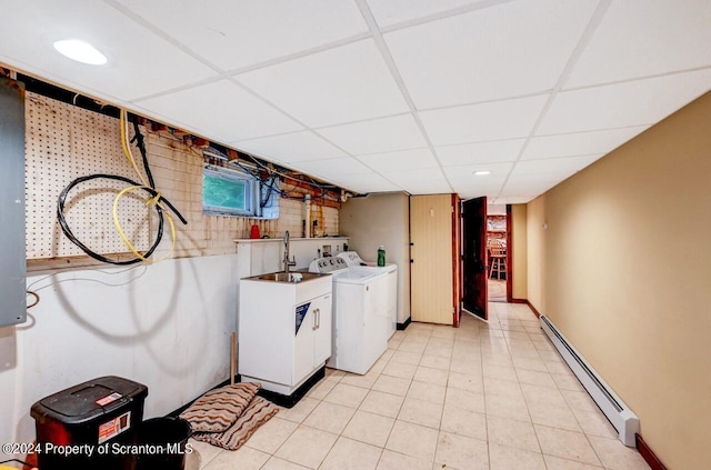 laundry area with light tile patterned floors, a baseboard radiator, washer and clothes dryer, and sink