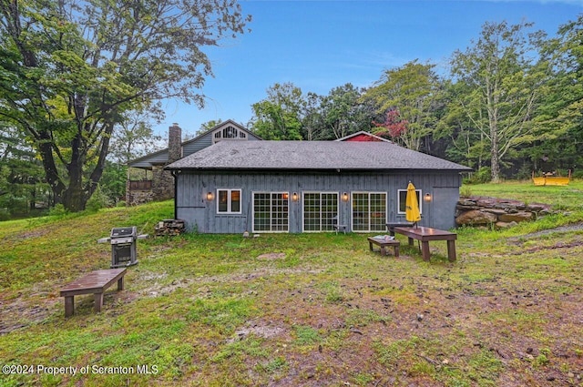 rear view of property with a lawn