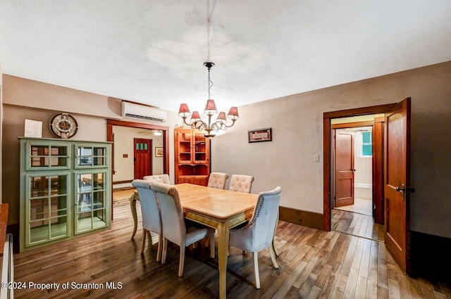 dining room with a wall mounted air conditioner, hardwood / wood-style floors, and a chandelier