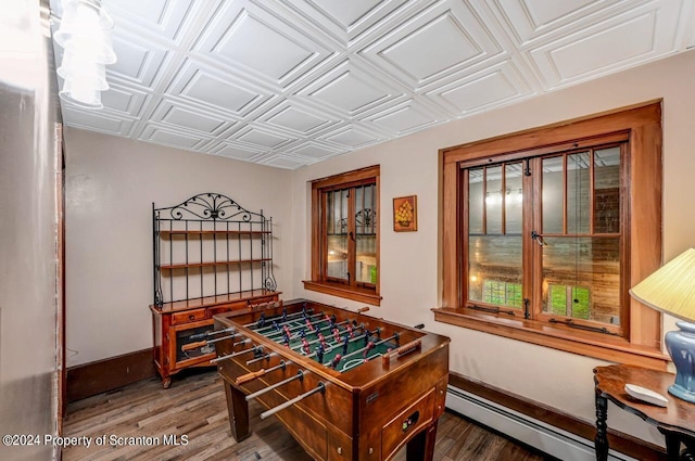 playroom with a baseboard heating unit and dark wood-type flooring