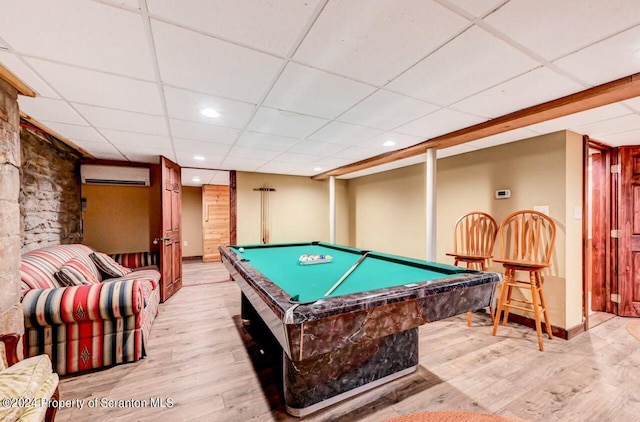 playroom featuring a drop ceiling, light wood-type flooring, billiards, and an AC wall unit