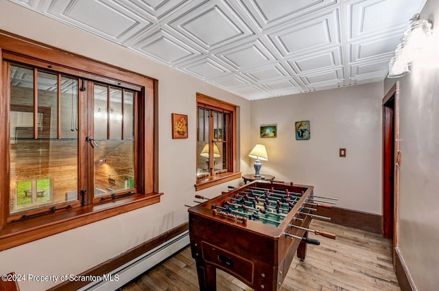 playroom featuring hardwood / wood-style floors and a baseboard heating unit