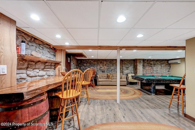 recreation room with a paneled ceiling, billiards, a wall mounted air conditioner, and hardwood / wood-style flooring