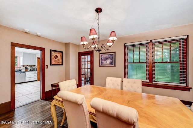 dining area featuring wood-type flooring and an inviting chandelier