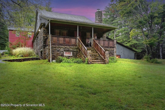 back house at dusk with a lawn