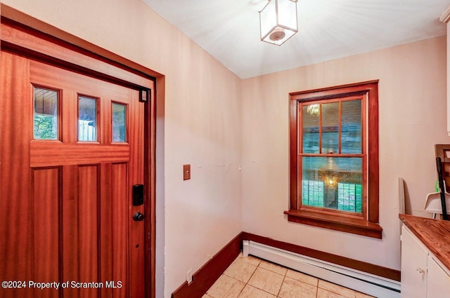 tiled foyer with a baseboard heating unit