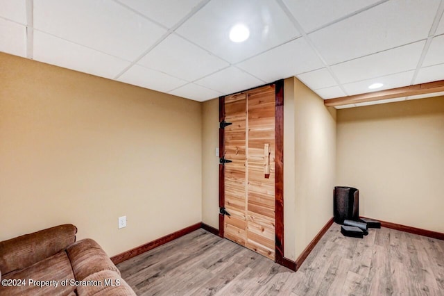 interior space with a paneled ceiling and hardwood / wood-style floors