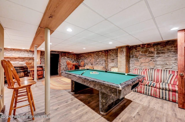 recreation room featuring light hardwood / wood-style floors, rustic walls, a drop ceiling, and pool table