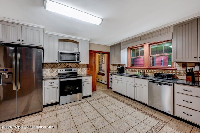 kitchen featuring appliances with stainless steel finishes, backsplash, crown molding, a baseboard heating unit, and sink