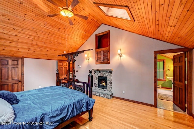 bedroom featuring ceiling fan, vaulted ceiling with skylight, wood ceiling, and light hardwood / wood-style flooring