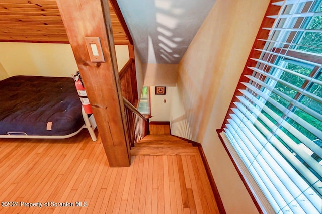 stairs featuring hardwood / wood-style flooring and wood ceiling