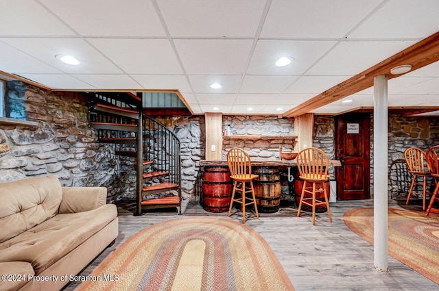 bar with a paneled ceiling and hardwood / wood-style flooring