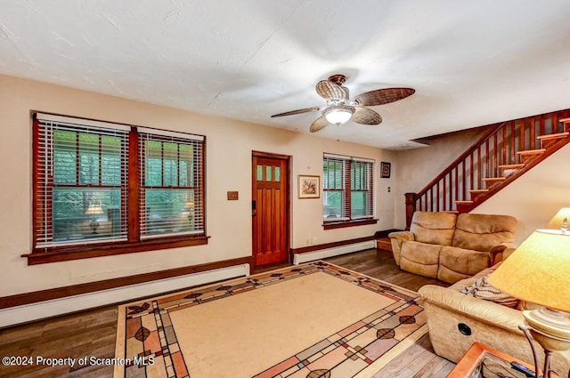 unfurnished living room with ceiling fan, a baseboard radiator, and wood-type flooring