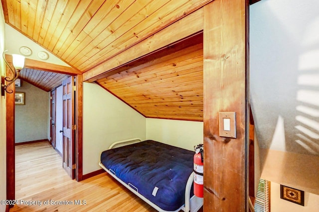 bedroom with light wood-type flooring, lofted ceiling, and wood ceiling