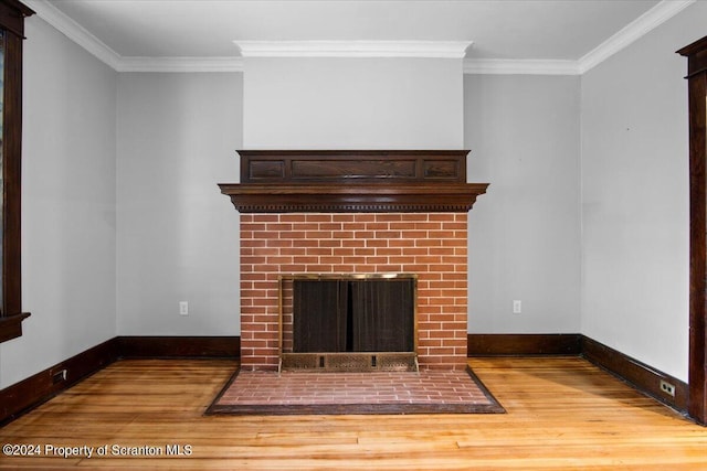 unfurnished living room with hardwood / wood-style flooring, a brick fireplace, and ornamental molding