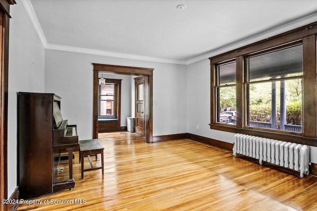 spare room with hardwood / wood-style floors, radiator, and ornamental molding