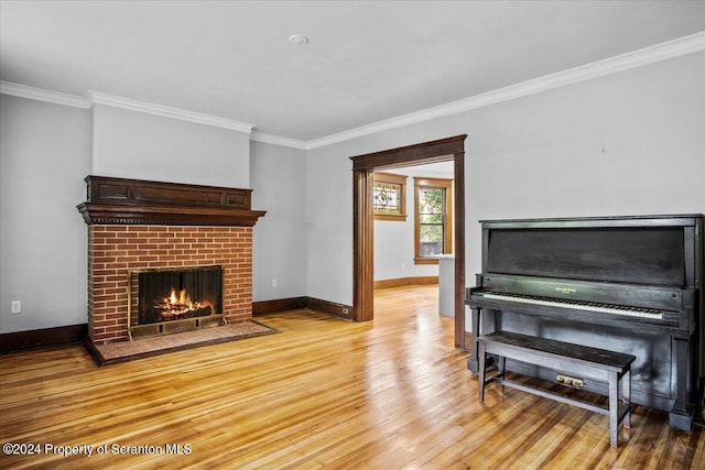 living room with ornamental molding, light hardwood / wood-style flooring, and a brick fireplace