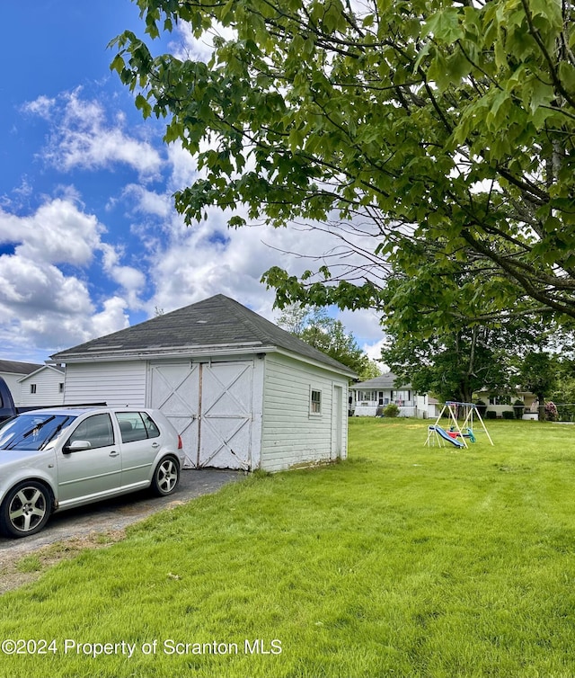 view of side of property with a lawn and an outbuilding