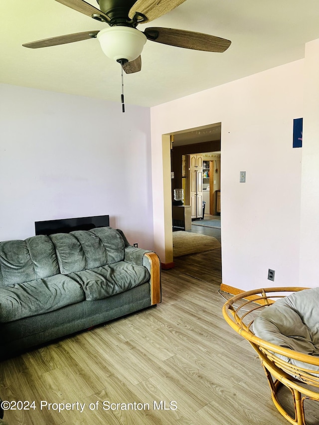 living room featuring light wood-type flooring and ceiling fan