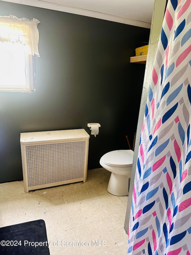 bathroom featuring a shower with curtain, toilet, and radiator heating unit