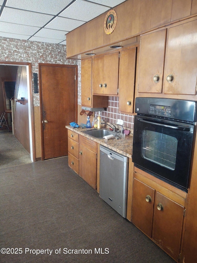 kitchen featuring a paneled ceiling, oven, a sink, dishwasher, and brown cabinetry