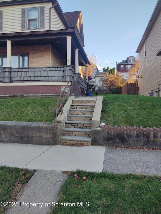 view of side of property with a porch and a yard